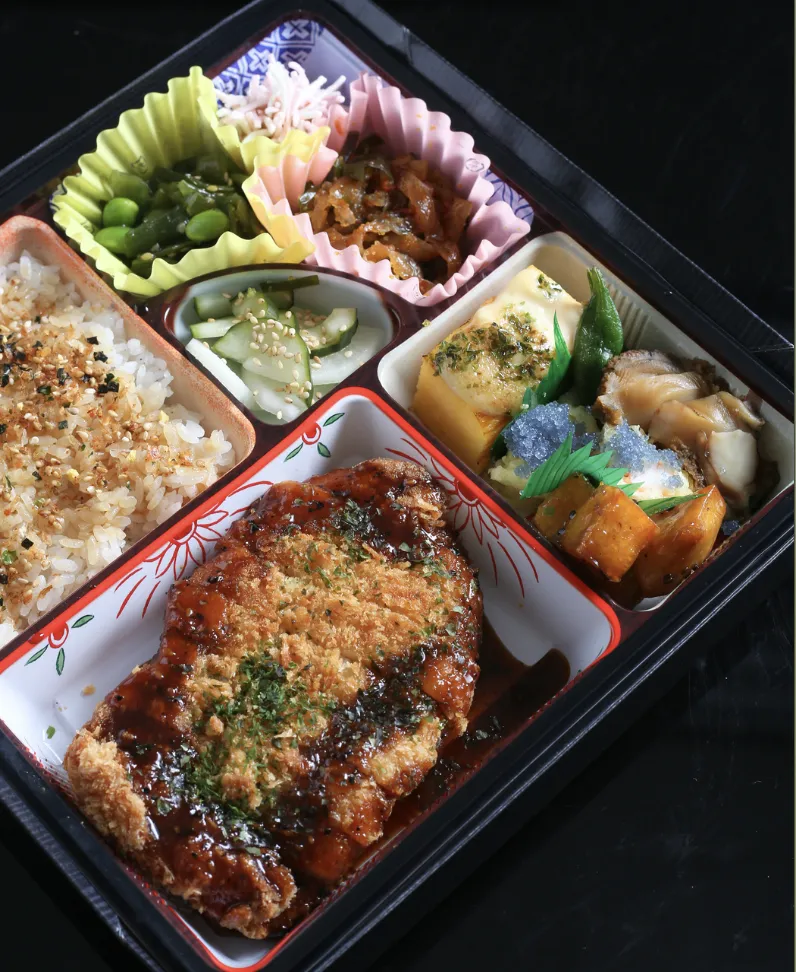 Classic Japanese Bento box with rice, fish, and vegetables
